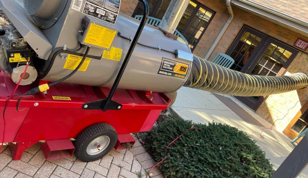 Portable HVAC rental unit external exhaust hose at hotel entrance.